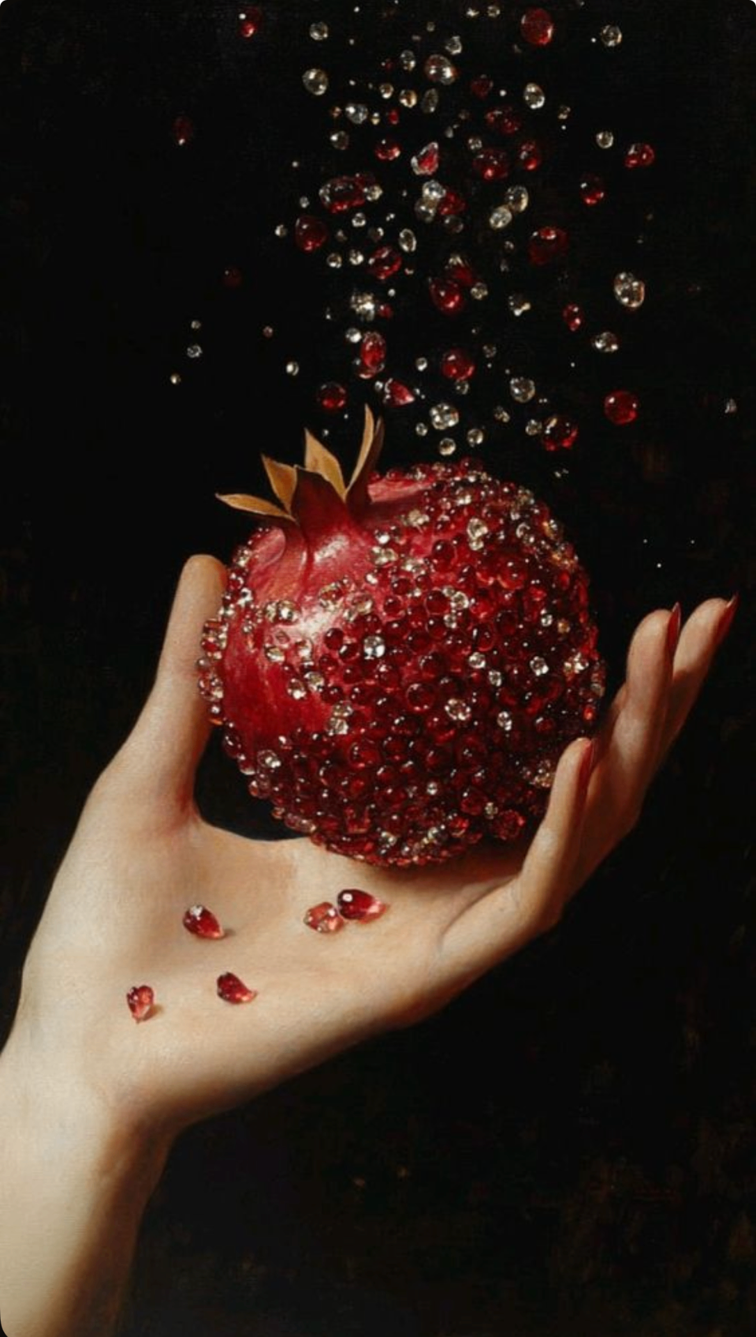 A hand cradling a split pomegranate, garnet seeds catching candlelight
